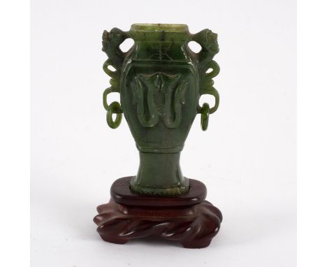 A Chinese spinach jade urn of square baluster section with scrolling ring handle and dragon carving, 20th Century (cover miss