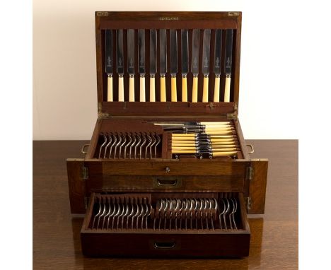 An oak canteen of silver plated flatware for twelve place settings, the canteen with knives in cover above a tray and two dra