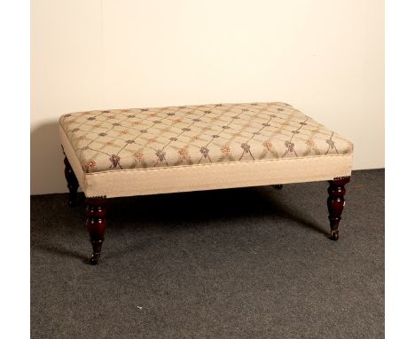 A low upholstered stool on turned legs, 51cm wide