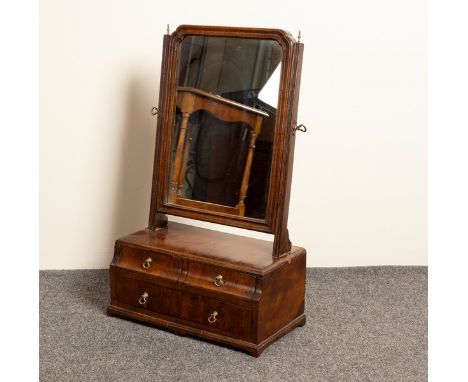 An 18th Century walnut swing frame mirror, the base fitted two short over one long drawer, on bracket feet, 35.5cm wide