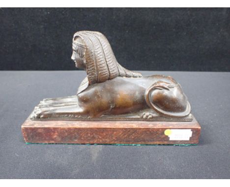 A 19th CENTURY GRAND TOUR STYLE BRONZE SPHINX on wooden base 19.5cm long