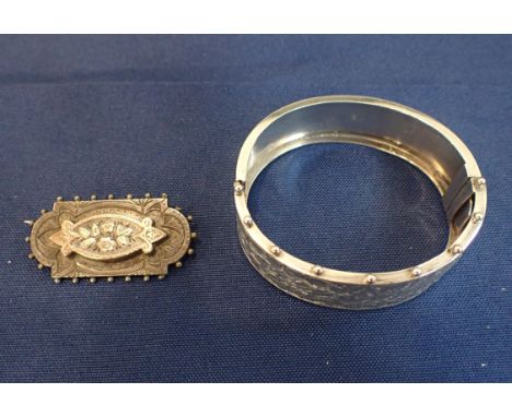 A VICTORIAN BANGLE AND BROOCH in sterling silver, the hinged bangle engraved to the top with leaves, beaded edges, partial Br