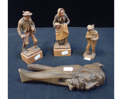 THREE BLACK FOREST STYLE CARVED FIGURES a farmer and his wife and an old man with a pipe, with a carved figural nutcracker