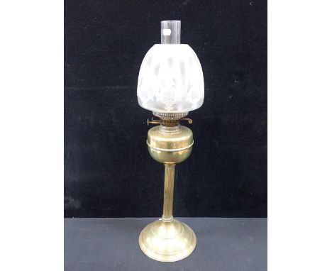 A BRASS TABLE OIL LAMP AND SHADE the shade with etched design, on reeded column and spreading base, 71cm including chimney