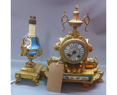 A late 19th century French gilt metal mantle clock, the porcelain dial with Roman numerals, urn finial, raised on bracket fee