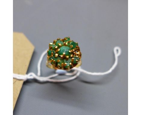 A ladies yellow metal dress ring, inset with green stones 