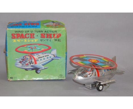 A boxed Japanese tinplate clockwork Space Ship with 'Wind-up U-turn action'. Model generally G+ although spring appears weak 