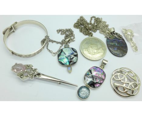 A hallmarked silver bangle, three silver mounted pendants, etc.