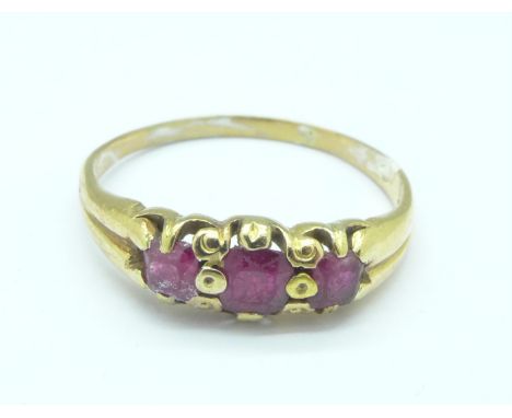 A yellow metal and three red stone ring, tests as 14ct, 2.7g, R