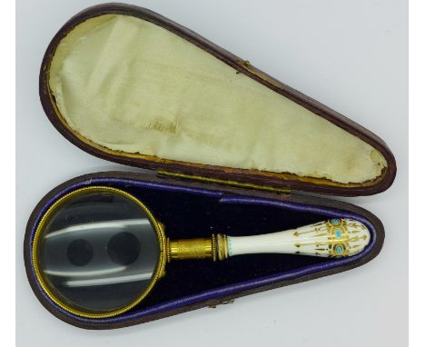 A continental gilt brass and ceramic magnifying glass, the handle with blue enamel and gilt decoration, in a fitted case, han