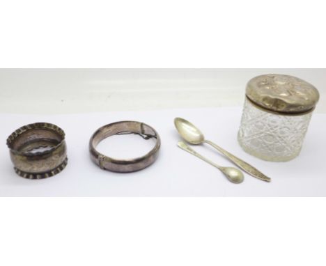 A silver topped jar, a silver bangle, two silver spoons and a silver napkin ring