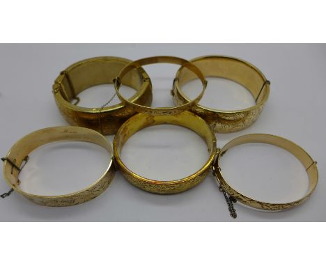 A silver-gilt bangle, three rolled gold bangles and two gold plated bangles