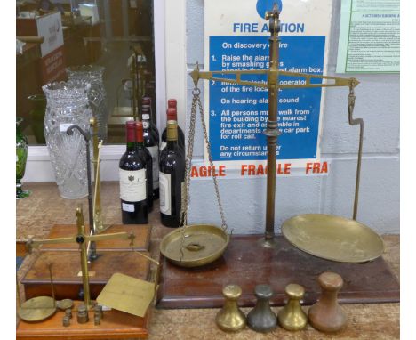 A set of large brass balance scales on a mahogany stand, three other sets of balance scales and four capstan weights includin