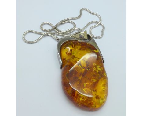 A large silver and amber pendant and chain
