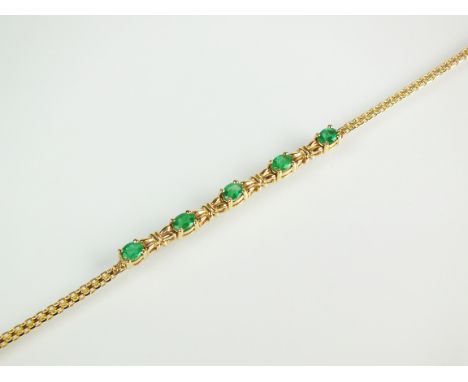 An emerald set bracelet, designed as five oval mixed cut emeralds each claw set between stylised bow links and attached to ye