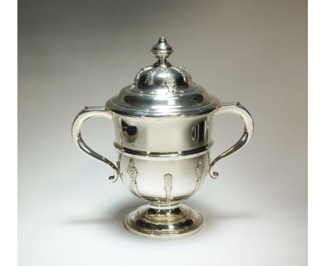 A two handled silver trophy cup and cover, Barker Brothers Silver Ltd, Birmingham 1931, the body with central band and applie