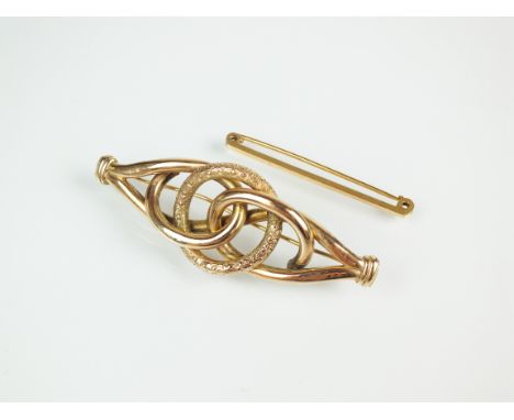 A late 19th century yellow metal hollow scroll brooch, 7cm long, together with a 15ct gold tie pin bar brooch, total weight a