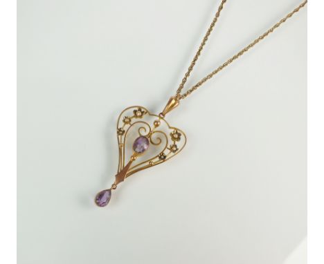 An early 20th century amethyst and split seed pearl set pendant, designed as a central oval mixed cut amethyst milligrain set