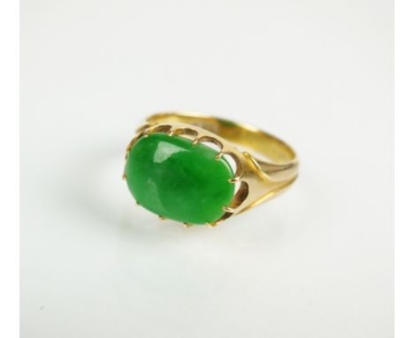 A jade dress ring, designed as a single oval jade plaque claw set in yellow metal to yellow metal shank, stamped '18', ring s