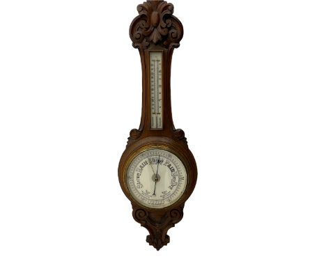 An English 1930�s solid oak carved hall barometer in a scroll shaped carved case with relief carving, aneroid movement, 8� wh