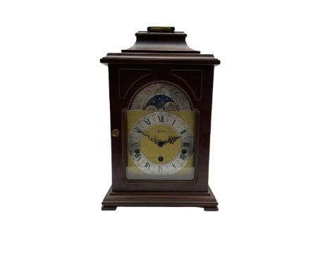 A 20th century Bracket clock in mahogany effect case with bell top pediment and glazed break arch door, with a brass dial and