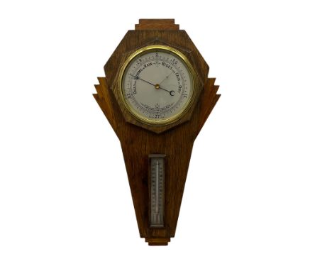A mid-20th century British made aneroid barometer housed in an inverted oak case in the art deco style,  with a six-inch silv