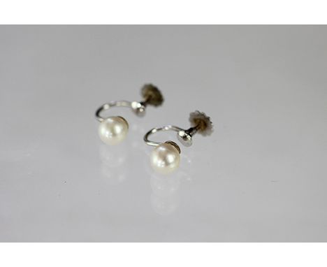 A pair of untested pearl set screw earrings, each stamped '9ct' to the white gold fittings 