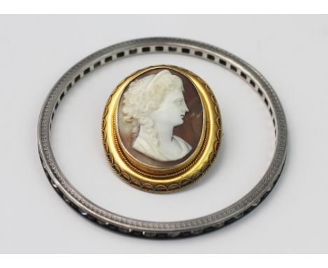 An Art Deco bangle, set with alternating black and colourless paste stones and all set in white metal, along with a carved sh