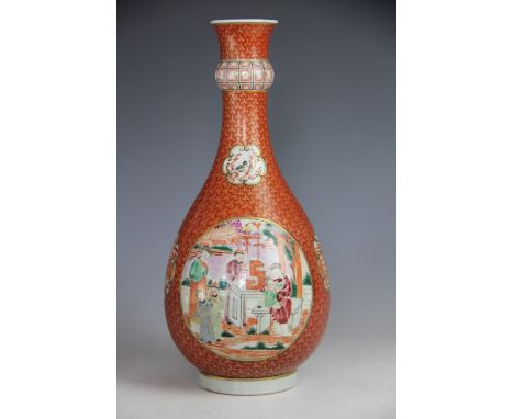 A Chinese porcelain famile verte bottle vase, decorated with reserves of figures playing with puppies and temples against an 