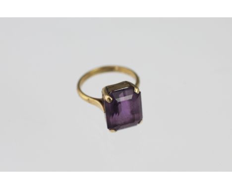 An amethyst set dress ring, the rectangular cut stone within four claw yellow gold setting stamped '9ct', weight 4.8gms 