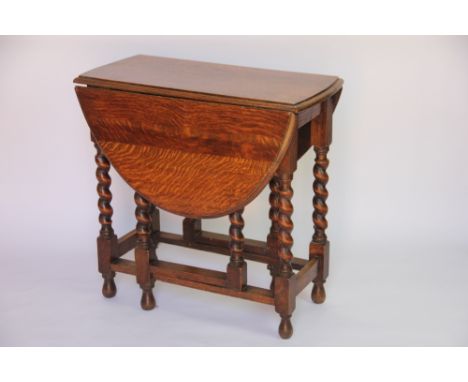 A 1920's oak gate leg table, on barley twist legs, 71cm H x 106cm W x 74cm D
