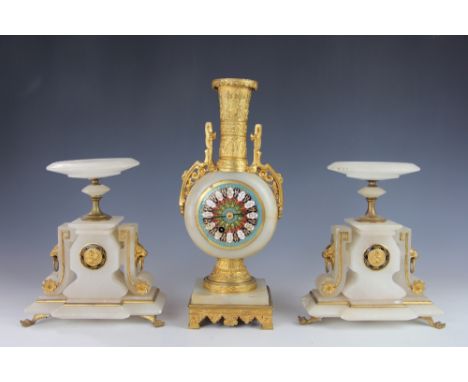 A late 19th century gilt brass and onyx clock garniture, the moon flask shaped time piece with enamel Roman numeral dial and 