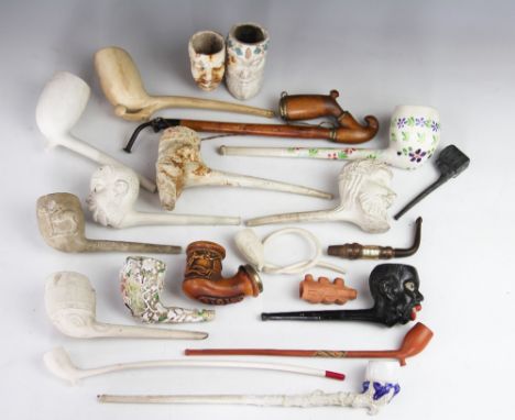 A collection of 19th century clay pipes, including one with a Jockey impressed Donovan, Bacchus heads, negro heads, a glazed 