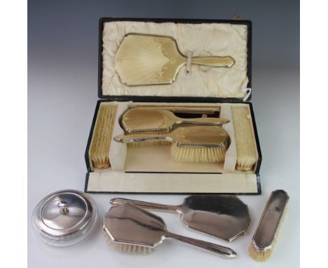 A silver and yellow enamel five piece dressing table set, Birmingham 1929, cased, with a silver and glass powder bowl and a t