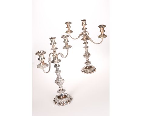A PAIR OF PLATED THREE-LIGHT CANDELABRA, SECOND HALF 19TH CENTURY, each on shaped circular base with foliage scroll band, the