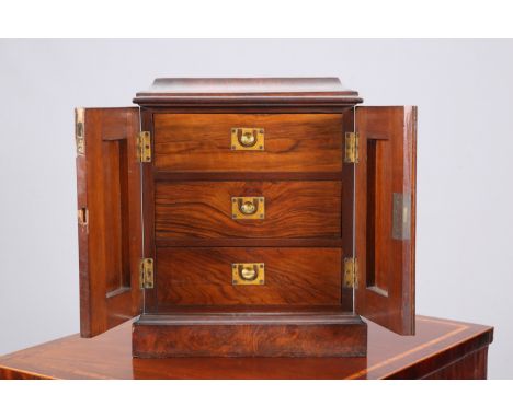 A WALNUT COLLECTOR'S CABINET, the moulded caddy top above a pair of fielded arched panel doors opening to three drawers, each