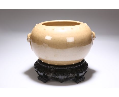 A CHINESE BROWN GLAZED BOWL, with moulded mask and ring "handles", on a carved zitan stand. Bowl 15.5cm high