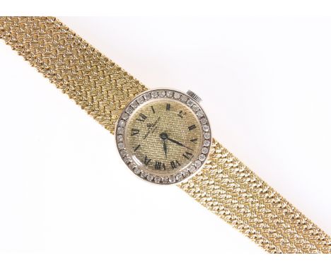 A BAUME &amp; MERCIER GOLD AND DIAMOND WRIST WATCH. Circular gilt dial with textured pattern, printed roman index and black h