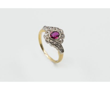A RUBY AND DIAMOND RING, the oval cut ruby set with a twist design mount set throughout with thirteen old brilliant cut diamo