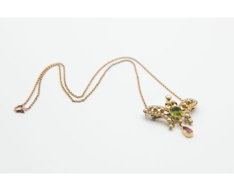 AN ART NOUVEAU PERIDOT, TOURMALINE AND SEED PEARL PENDANT, the symmetrical wing design mount set throughout with graduating s