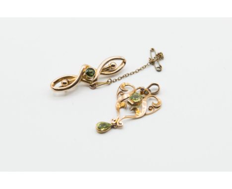AN ART NOUVEAU 9CT GOLD AND PERIDOT PENDANT, the symmetrical scroll detail mount with pierced detailing set with two principl