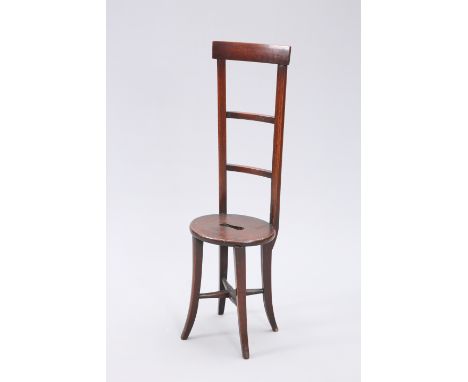 A 19TH CENTURY MAHOGANY CHILD'S CORRECTION CHAIR, with curved crest rail above a ladder back, the oval seat with cut-out hand