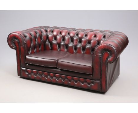 AN OX BLOOD LEATHER FOUR-PIECE CHESTERFIELD SUITE, comprising two-seater buttoned sofa, a pair of buttoned wing-back armchair