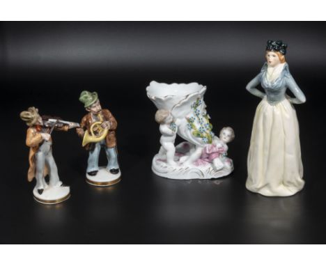 A Goebel figure of a lady, two small Continental figures and one other