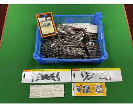 Approximately sixty-four 00 gauge points and crossings by Peco and Hornby, including three-way and slip points, together with