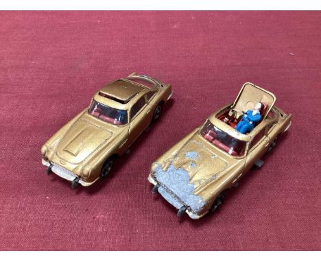 Two Original Corgi No 261 James Bond Aston Martin DB5's, gold, both with 'Baddy'. both playworn with faulty mechanisms.