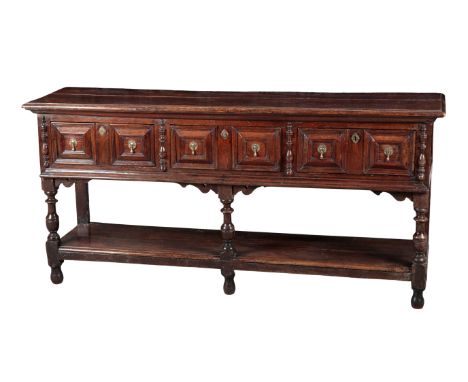 A CHARLES II OAK DRESSER BASE 17th century with later elements, the top with a moulded edge, over three frieze drawers with g