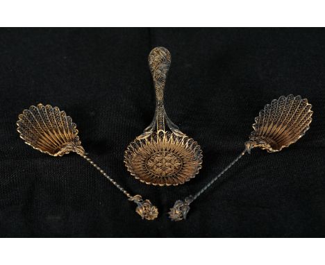 A 19TH CENTURY GILT FILIGREE WHITE METAL CADDY SPOON 13cm long and a pair of similar spoons, 14.5cm long