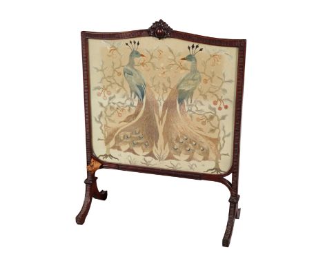 AN EDWARDIAN MAHOGANY FIRESCREEN 20th century, the cartouche shaped frame surrounding a silkwork panel depicting two peacocks