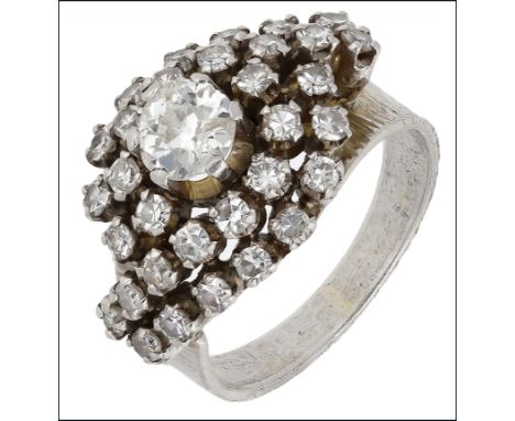 A diamond dress ring, circa 1960, the principle old-cut diamond claw set and centred within a swirling bombé surround of sing